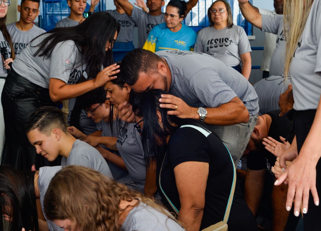 Missionários orando com imposição de mãos durante o avanço em Itapevi